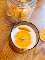 Joyful Spice candle featuring slices of orange on top, creating a warm and inviting ambiance.