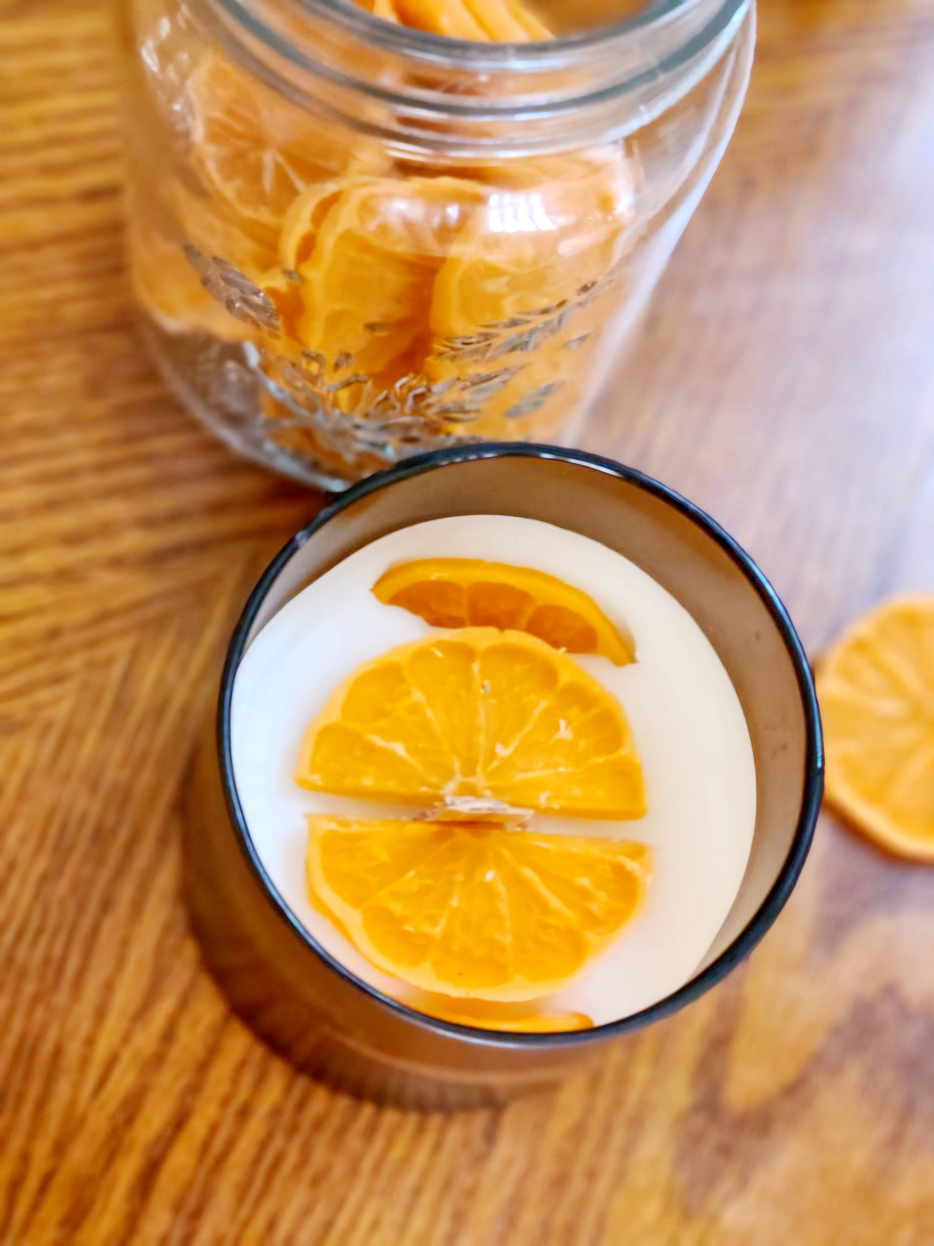 Joyful Spice candle featuring slices of orange on top, creating a warm and inviting ambiance.