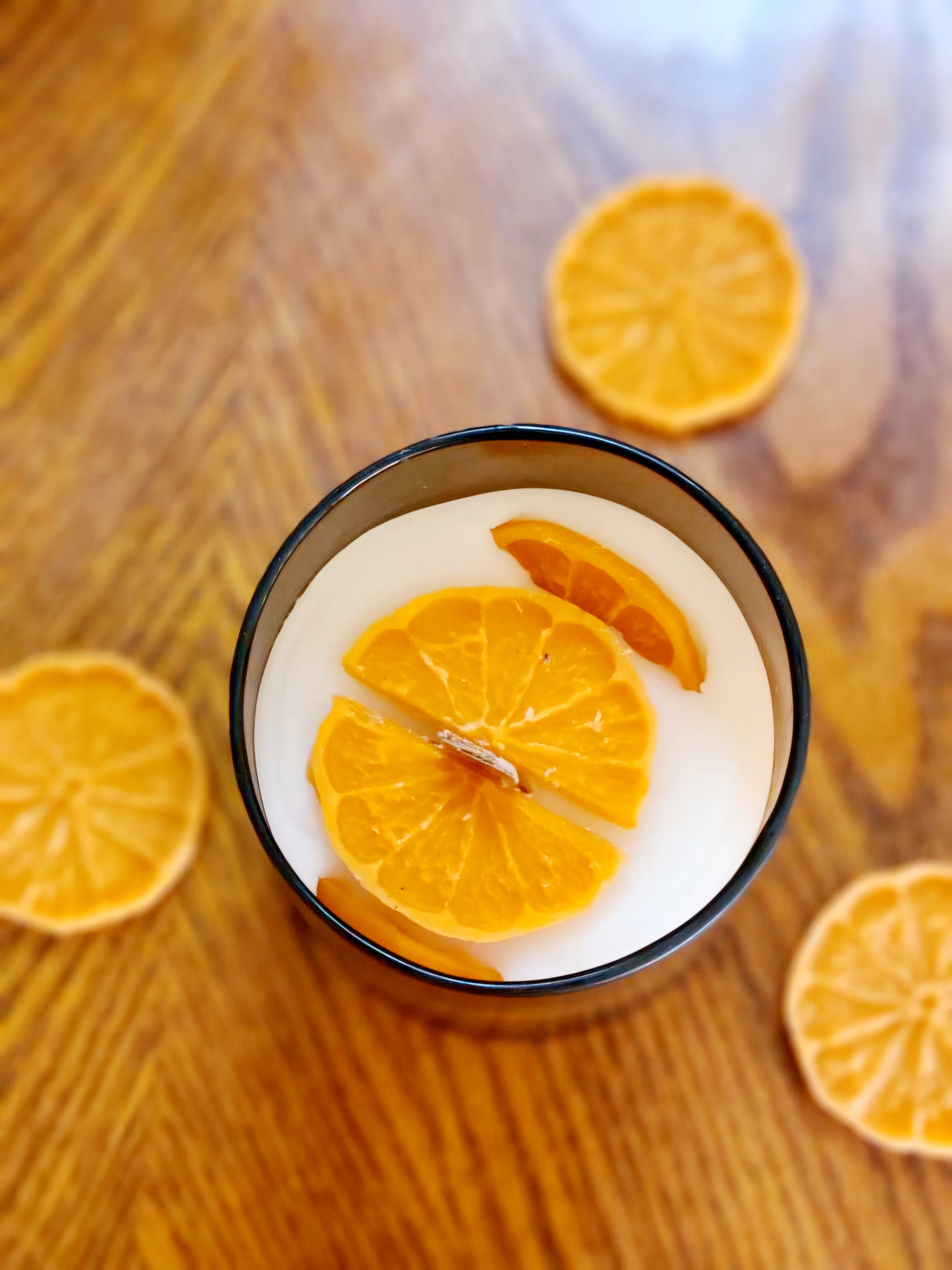 Joyful Spice candle with citrus slices on top, featuring bright orange and warm spice aromas.