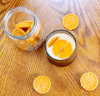 Joyful Spice candle with cinnamon orange clove scent surrounded by dried orange slices